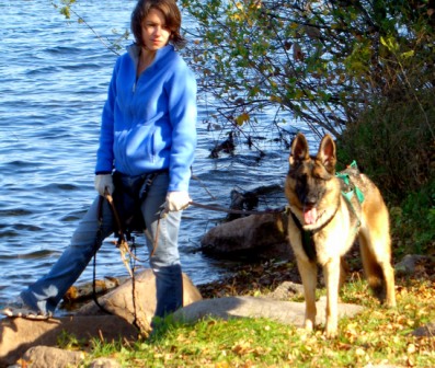Person and German Shepherd by the lake